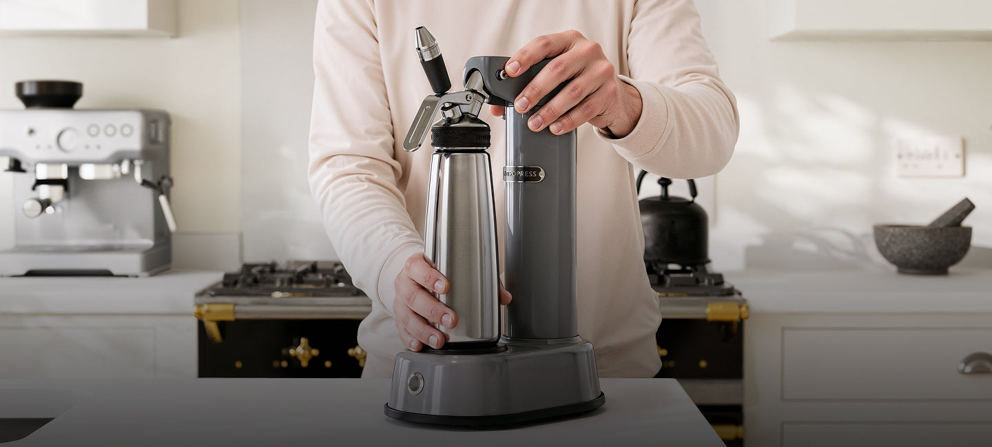 Person using a NitroPress coffee machine in a kitchen setting