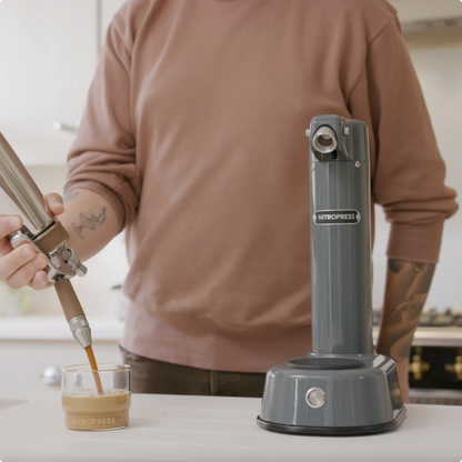 Person using a NitroPress coffee machine to make a coffee drink.